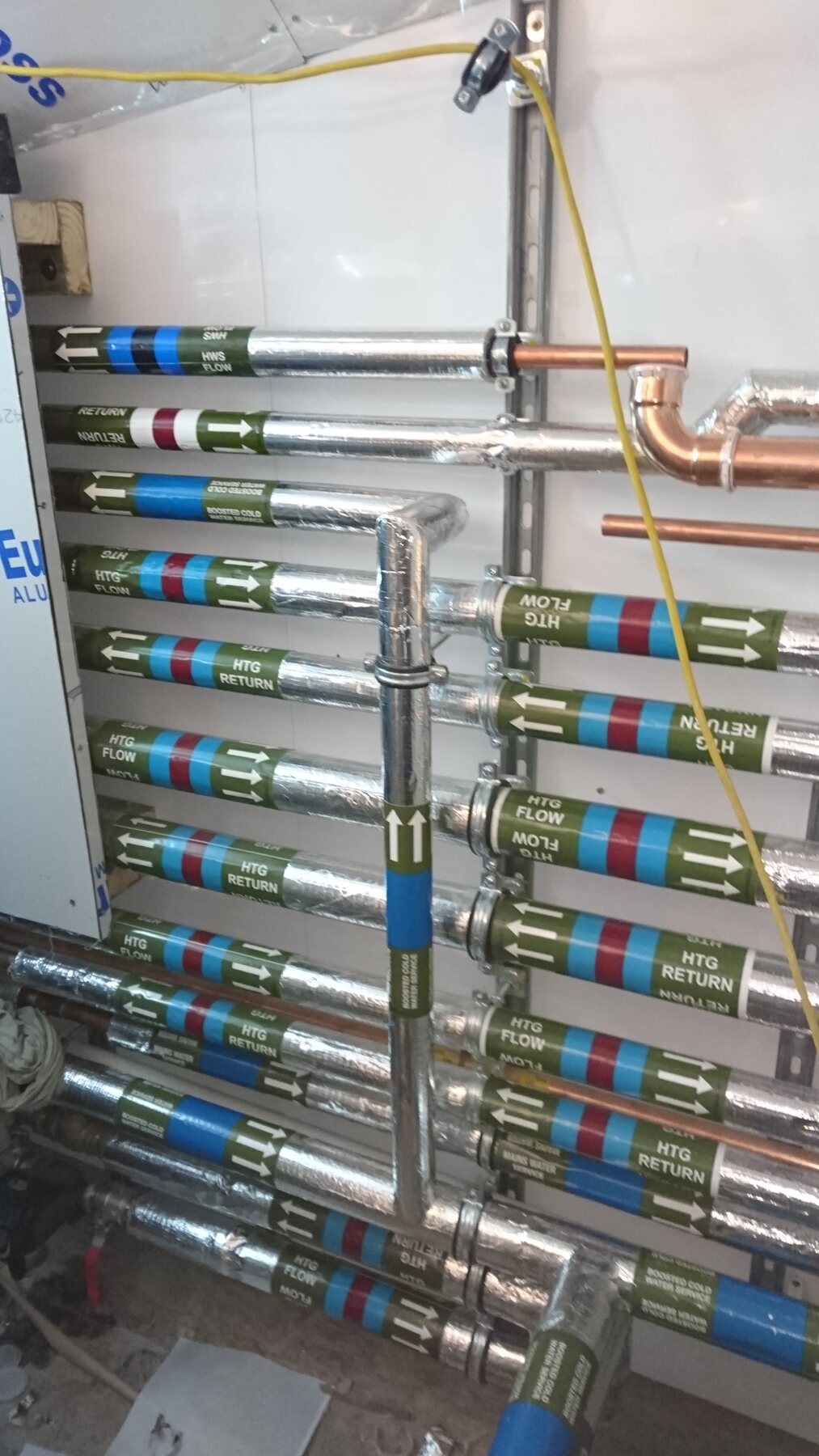 Labelled heating distribution pipework at Selwyn House in Westminster